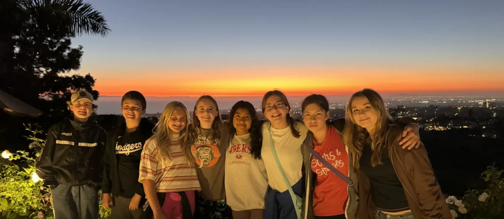 Mission Lutheran youth group gathered outdoors at sunset overlooking the city